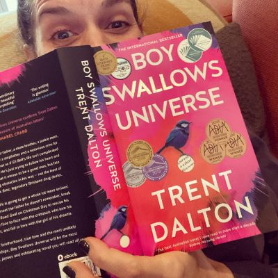 Photo fo Michala Banas while reading Boy Swallows Universe Book. 